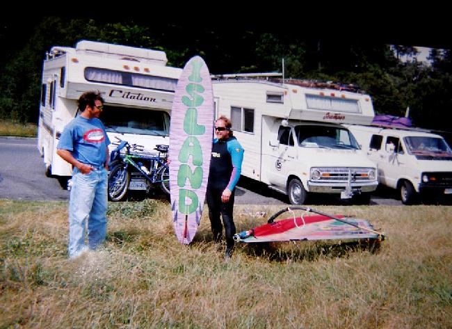 Johnny  Doo Bad
Here's an old one of Johnny with his favourite ,, Gorge Animal Bonser 7'6",,,,, still at cook ,,, that was his motorhome in the background to the right.. ,,taken about 1992, Island Sails was the name of his sail loft ,,, he had this board custom made in the Gorge with  "Island" graphics on the bottom...that was when he lived on 10 mile point with Jose and Kevin.... long time ago... can see his logo on his motorhome door ,,, ,,,  slim and trim in those days ,, 
